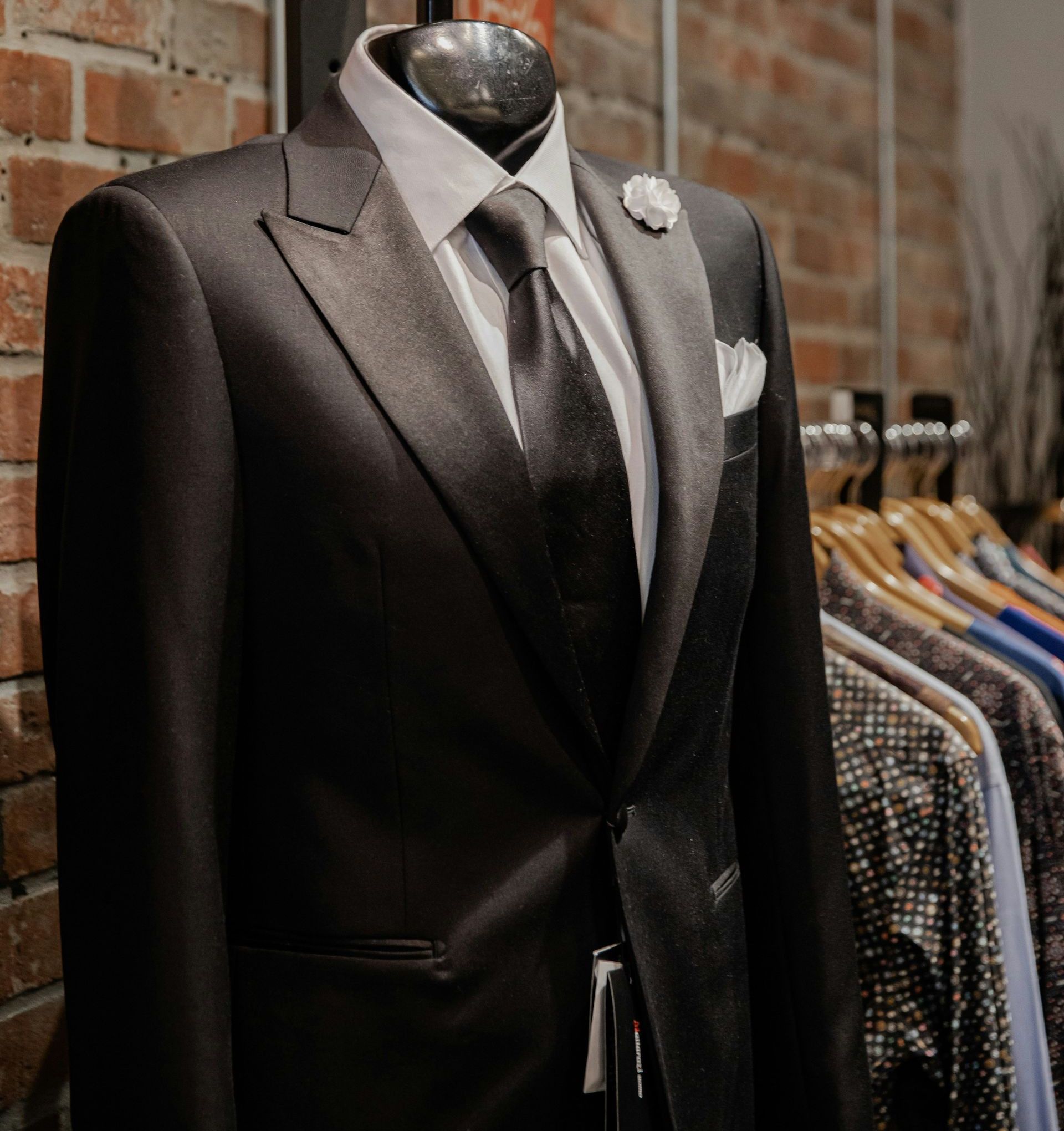 black suit jacket near brown brick wall